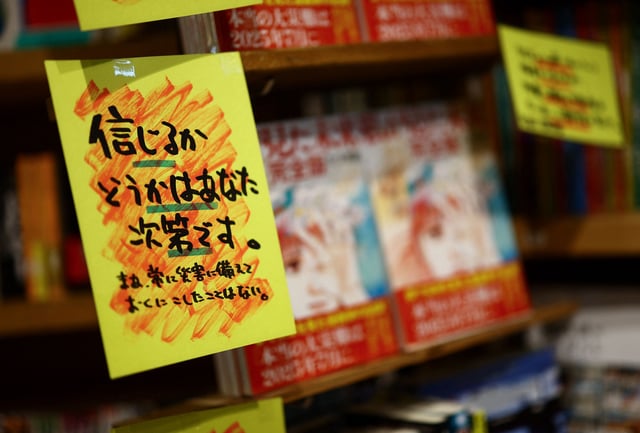 A sales banner written by the store reading 'Whether you believe it or not is up to you' is displayed next to the comic book titled 'The Future I saw', authored by manga artist Ryo Tatsuki, on the shelf at the book store Village Vanguard in Tokyo, Japan June 30, 2025. REUTERS/Issei Kato/File Photo