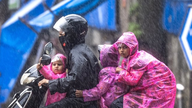 People going through the rain at Cotton Green in Mumbai, India, on Wednesday.