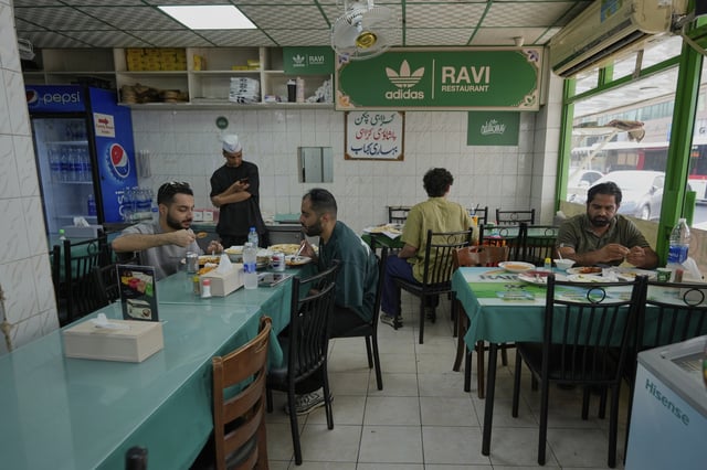 People dine at Ravi restaurant in Satwa district of Dubai, United Arab Emirates, Monday, June 9, 2025. (AP Photo/Altaf Qadri)