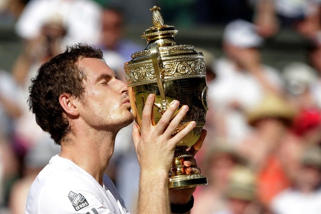 Andy Murray of Britain kisses the winners trophy after defeating Novak Djokovic of Serbia (R) in their men's singles final tennis match at the Wimbledon Tennis Championships, in London July 7, 2013. REUTERS/Anja Niedringhaus/Pool/File Photo