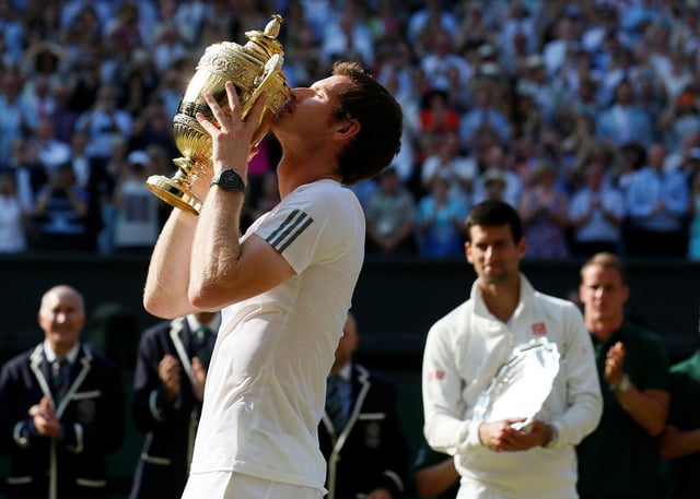 Andy Murray of Britain kisses the winners trophy after defeating Novak Djokovic of Serbia (R) in their men's singles final tennis match at the Wimbledon Tennis Championships, in London July 7, 2013. REUTERS/Stefan Wermuth/File Photo
