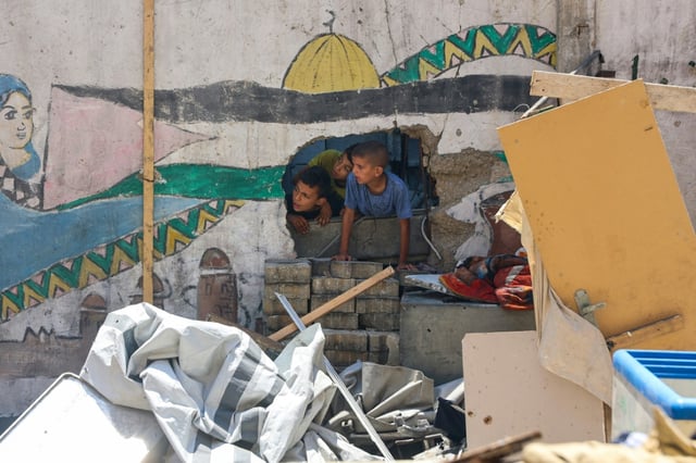 Des enfants constatent les dégats après le bombardement de l'école Mustafa Hafez, le 3 juillet 2025 à Gaza-ville