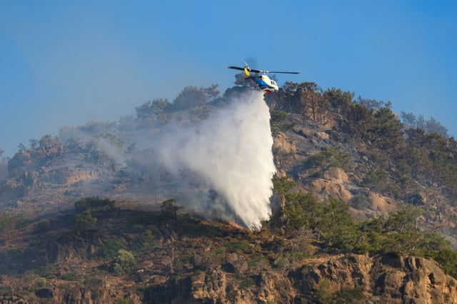 Un hélicoptère largue de l'eau sur un feu près de Ierapetra sur l'île grecque de Crète, le 3 juillet 2025