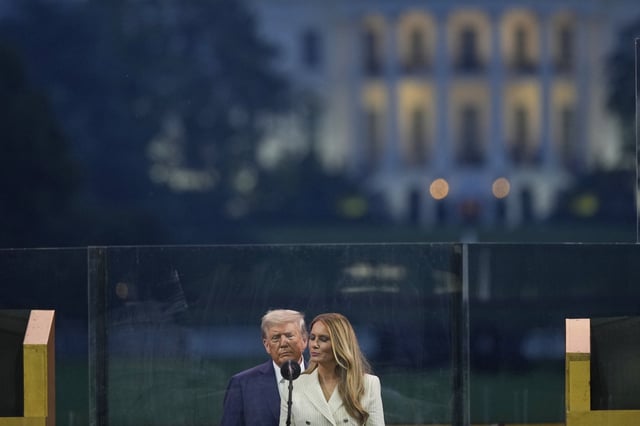 President Donald Trump and first lady Melania Trump pauses on stage during a military parade commemorating the Army's 250th anniversary, coinciding with his 79th birthday, Saturday, June 14, 2025, in Washington. (AP Photo/Julia Demaree Nikhinson)