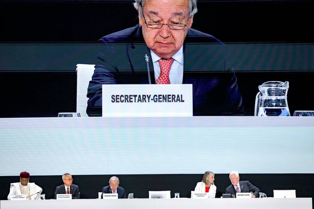UN-Generalsekretär Antioni Guterres ist auf einem Bildschirm zu sehen, wie er bei der Bekanntgabe der Tagesordnung vom Podium aus spricht