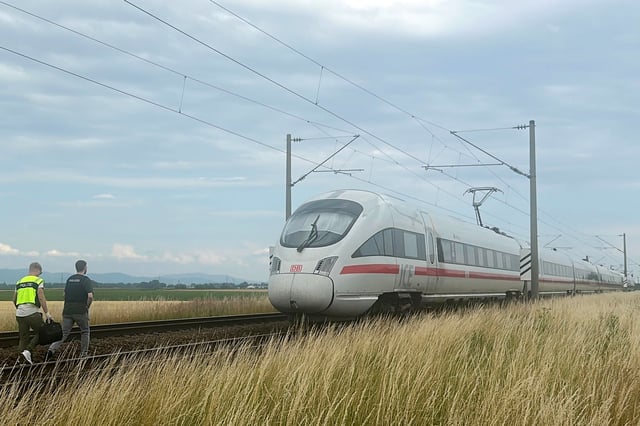 Polizeibeamte gehen zu dem ICE, in dem ein Mann in Niederbayern mehrere Passagiere angegriffen hat.