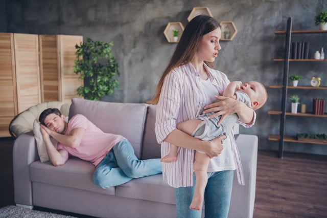Portrait of attractive careful spouses full family rocking cute infant asleep calm rest time at living room home indoors.