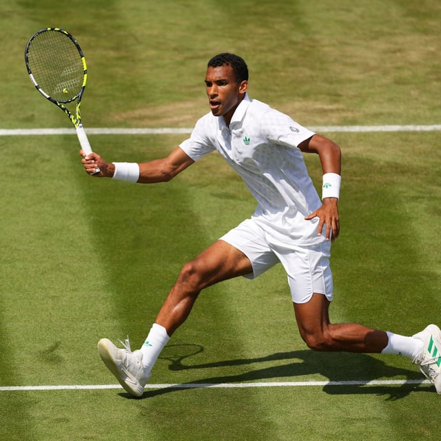 Felix Auger‑Aliassime of Canada returns the ball to Jan-Lennard Struff of Germany during their second-round men's singles match at the Wimbledon Tennis Championships in London, Thursday, July 3, 2025. (AP Photo/Kirsty Wigglesworth)