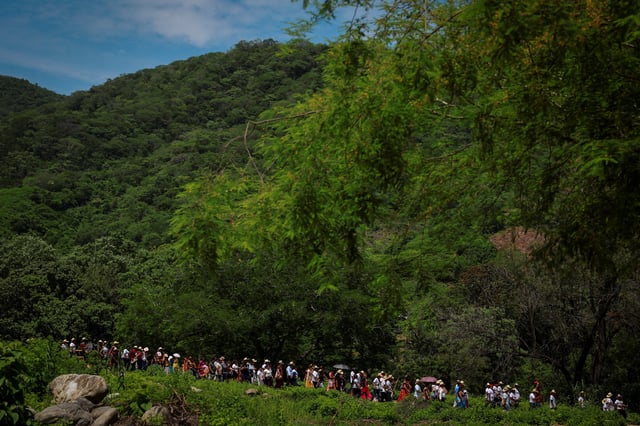 Members of the community of San Pedro Huamelula walk in a procession before the symbolic marriage of a female caiman named "princess girl" Miguelana Estela del Mar Zavaleta Ramirez, a reptile that closely resembles an alligator, to San Pedro Huamelula mayor Daniel Gutierrez Pena in a ritual rooted in more than 230 years of tradition and union joins two of Oaxaca state's indigenous cultures, the Chontal and the Huave, to plead for nature's bounty, in San Pedro Huamelula, Mexico, June 30, 2025. REUTERS/Raquel Cunha