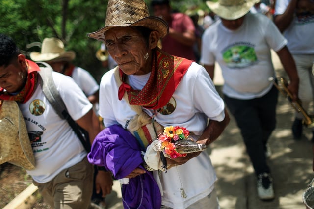 A member of the community of San Pedro Huamelula walks in a procession to present a female caiman named "princess girl" Miguelana Estela del Mar Zavaleta Ramirez, a reptile that closely resembles an alligator, to San Pedro Huamelula mayor Daniel Gutierrez Pena for a symbolic marriage rooted in more than 230 years of tradition and joins two of Oaxaca state's indigenous cultures, the Chontal and the Huave, to plead for nature's bounty, in San Pedro Huamelula, Mexico, June 30, 2025. REUTERS/Raquel Cunha