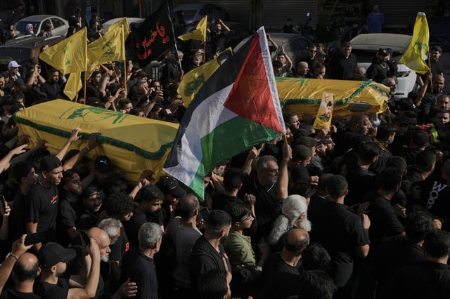 Mourners carry the coffins of Abu Ali Khalil, the bodyguard and head of security for late Hezbollah leader Sayyed Hassan Nasrallah, and his son Mahdi, who were killed in an Israeli airstrike in Iran on June 21, during their funeral procession in Dahiyeh, a southern suburb of Beirut, Lebanon, Thursday, July 3, 2025. (AP Photo/Bilal Hussein)