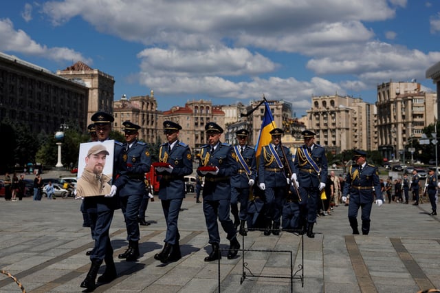 Service members of Honour Guard carry a portrait of Ukrainian military pilot Colonel Maksym Ustymenko, who died last Sunday operating an F16 fighter jet during a combat mission, amid Russia's attack on Ukraine, during his funeral ceremony at the Independence Square in Kyiv, Ukraine July 3, 2025.  REUTERS/Valentyn Ogirenko