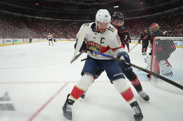 May 28, 2025; Raleigh, North Carolina, USA; Carolina Hurricanes defenseman Dmitry Orlov (7) battles for the puck against Florida Panthers forward Aleksander Barkov (16) during the first period in game five of the Eastern Conference Final of the 2025 Stanley Cup Playoffs at Lenovo Center. Mandatory Credit: James Guillory-Imagn Images/File Photo
