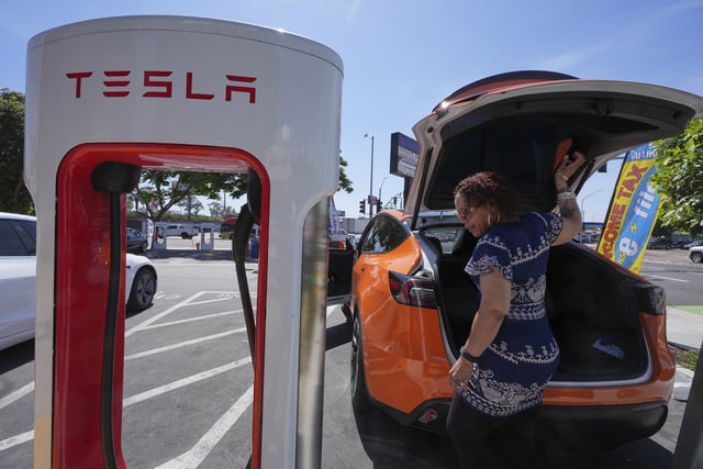 FILE - Janelle Lowe prepares to charge her electric vehicle at a station May 22, 2025, in Long Beach, Calif. (AP Photo/Damian Dovarganes, File)