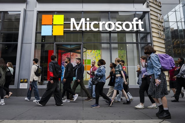 People walk by the Microsoft Office building on 41st street and 8th avenue on May 13, 2025 in New York City.