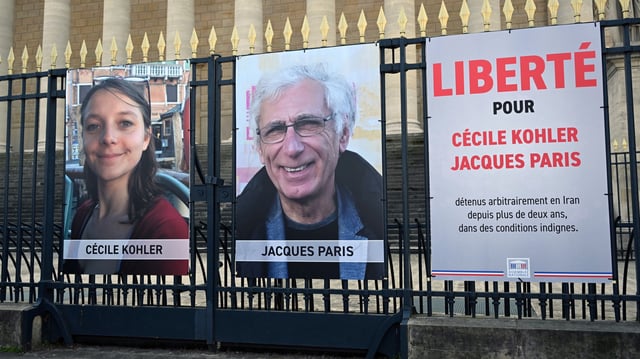 Les portraits de Cécile Kohler et de Jacques Paris, tous deux emprisonnés en Iran, étaient affichés, en mars, sur les grilles entourant l’Assemblée nationale.