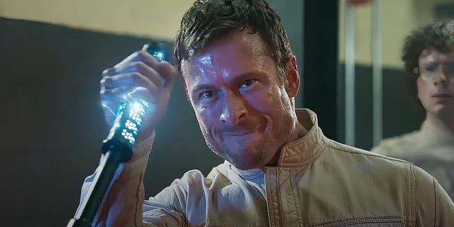 Glen Powell as Ben Richards holding a stun stick in The Running Man.