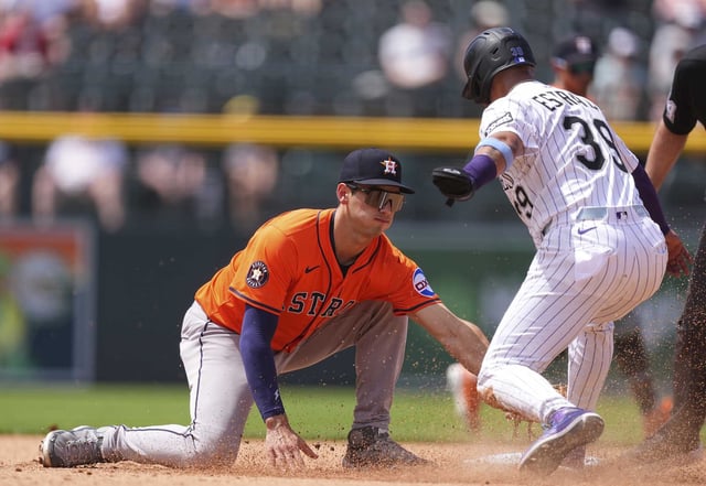 Houston Astros second baseman Shay Whitcomb, left, tags out Colorado Rockies&#39; Thairo Estrada as he tries to steal second base to end the fifth inning of a baseball game Thursday, July 3, 2025, in Denver. (AP Photo/David Zalubowski)