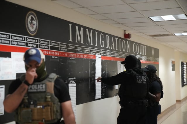 U.S. Immigration and Customs Enforcement agents look over lists of names and their hearing times and locations inside the Federal Plaza courthouse before making arrests on June 27, 2025, in New York.