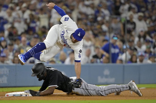 Los Angeles Dodgers third baseman Max Muncy (13) is injured as he flips over Chicago White Sox right fielder Michael A. Taylor (21) after tagging him out on an attempted steal in the fifth inning at Dodger Stadium in Los Angeles, California on July 2, 2025.