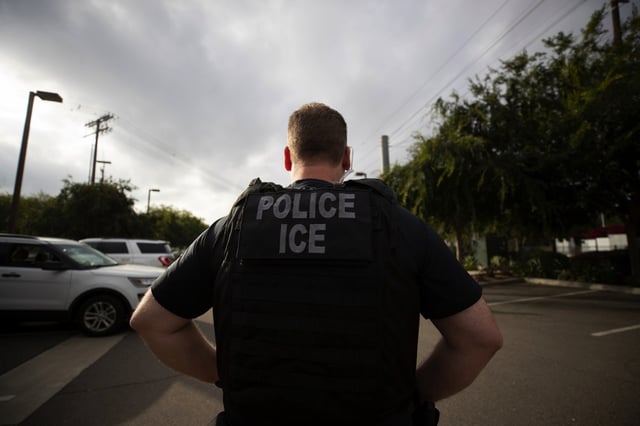 FILE - In this July 8, 2019, file photo, a U.S. Immigration and Customs Enforcement (ICE) officer looks on during an operation in Escondido, Calif.  (AP Photo/Gregory Bull, File)