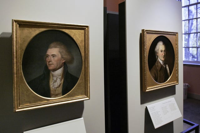 FILE - Portraits of a red-headed Thomas Jefferson, left, and John Dickinson, right, by by Charles Willson Peale are seen at the refurbished Second Bank of the United States in Philadelphia on Nov. 26, 2004. (AP Photo/Jacqueline Larma, File)