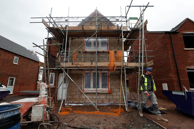 A construction worker walks on the construction site of residential buildings in Worcester, Britain December 5, 2024. REUTERS/Temilade Adelaja/File photo