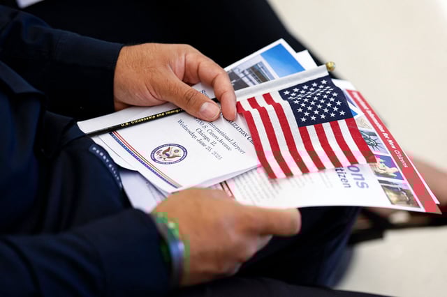 A new US citizen holds a program before receiving their naturalization certificates during a formal ceremony at Midway International Airport in Chicago, on June 25.