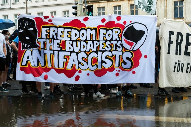 Demonstrierende tragen ein Banner, mit dem sie die Freiheit für die Antifaschisten fordern, die wegen der Budapest-Angriffe inhaftiert sind.