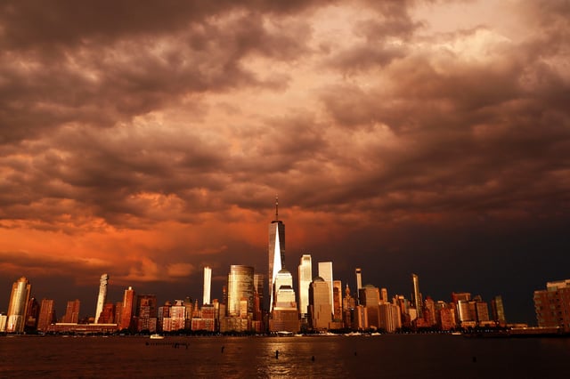 Clouds pass over the skyline of lower Manhattan and One World Trade Center as the sun sets following a storm in New York City on July 3, 2025, as seen from Jersey City, New Jersey.