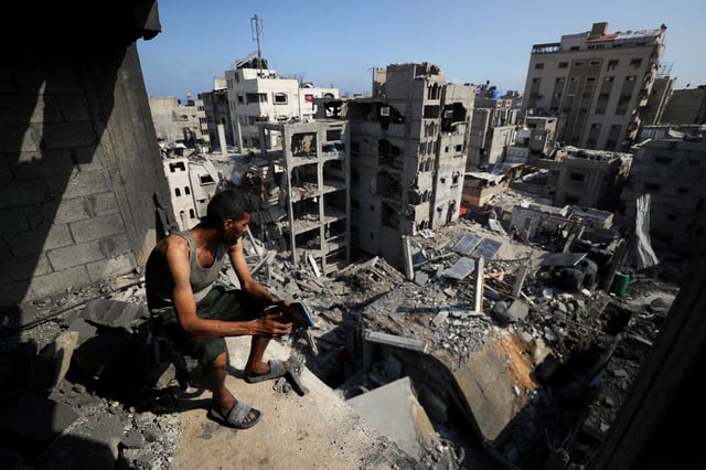A Palestinian looks on at the site of Thursday's Israeli strike that damaged and destroyed residential buildings, at Shati (Beach) refugee camp, in Gaza City, July 4, 2025. REUTERS/Mahmoud Issa