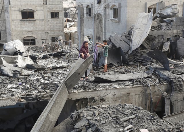 Palestinians inspect the site of Thursday's Israeli strike that damaged and destroyed residential buildings, at Shati (Beach) refugee camp, in Gaza City, July 4, 2025. REUTERS/Mahmoud Issa