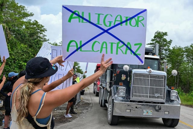 Trucks leave the Dade-Collier Transition and Training Airport as demonstrators protest the construction of an immigrant detention center, dubbed “Alligator Alcatraz,” in the Everglades near Ochopee, Florida, on Saturday, June 28, 2025. (Giorgio Viera/AFP/Getty Images North America/TNS)