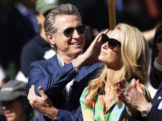 California Governor Gavin Newsom, left, waves to the crowd while attending the opening ceremony for Panda Ridge the new exhibit at the San Diego Zoo Thursday, Aug. 8, 2024, in San Diego. (AP Photo/Derrick Tuskan)