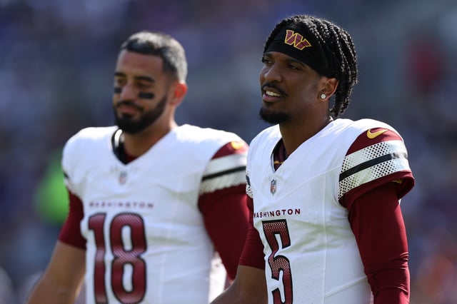 Jayden Daniels #5 of the Washington Commanders and quarterback Marcus Mariota #18 of the Washington Commanders look on against the Baltimore Ravens during the first half at M&amp;T Bank Stadium on October 13, 2024 in Baltimore, Maryland.