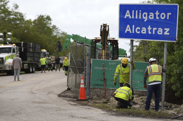 Workers install a sign reading &#34;Alligator Alcatraz&#34; at the entrance to a new migrant detention facility at Dade-Collier Training and Transition facility on Thursday, July 3, 2025, in Ochopee, Florida.