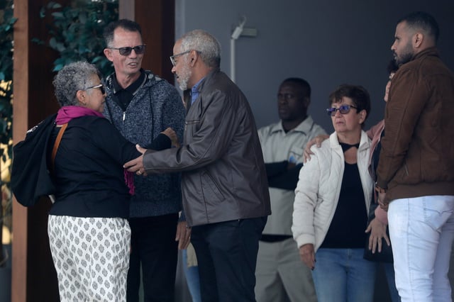 Manoel Marins, center, and Estela Marins, left, meet with friends during the funeral for their daughter Juliana Marins, who died after falling from the summit of Mount Rinjani in Indonesia, at Parque da Colina cemetery in Niteroi, Rio de Janeiro state, Brazil, Friday, July 4, 2025. (AP Photo/Bruna Prado)