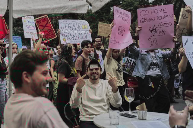 A man points to his Mexican ID to prove his nationality as people protest against gentrification, as the increase in remote workers has risen prices and increased housing demand in neighborhoods like Condesa and Roma, in Mexico City, Friday, July 4, 2025. (AP Photo/Jon Orbach)