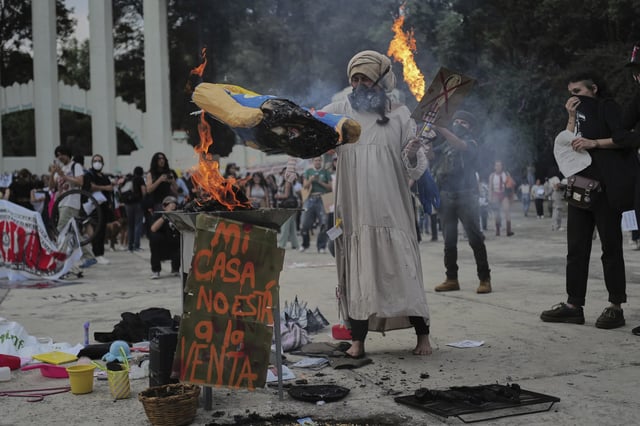 A demonstrator burns an effigy of U.S. President Donald Trump in Parque Mexico, during a protest against gentrification, as the increase in remote workers has risen prices and increased housing demand in neighborhoods like Condesa and Roma, in Mexico City, Friday, July 4, 2025. (AP Photo/Jon Orbach)