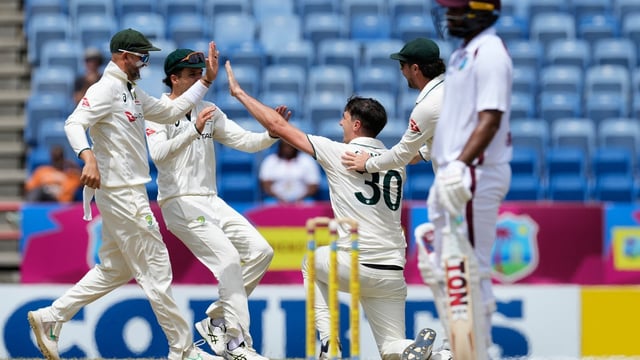 Pat Cummins celebrates with his teammates after taking a remarkable catch to dismiss Keacy Carty.