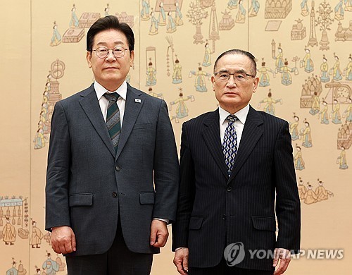 President Lee Mae-myung (L) presents a letter of appointment to National Security Adviser Wi Sung-lac at the presidential office in Yongsan, Seoul, in this photo taken July 4, 2025. (Pool photo) (Yonhap)