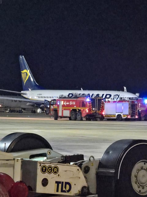 Un camión de Bomberos del aeropuerto de Palma, junto al avión de Ryanair incendiado esta madrugada.