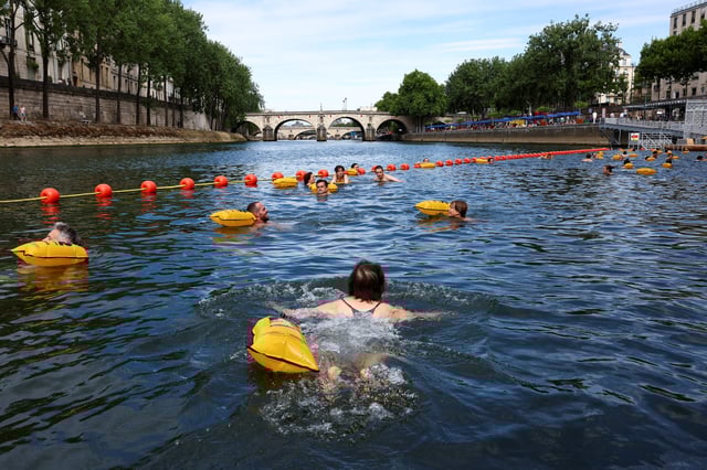People swim in the River Seine at the Bras Marie site, opened to swimmers marking the first public bathing session in the capital's historic waterway, in Paris, France, July 5, 2025. REUTERS/Abdul Saboor