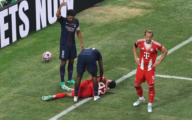 Soccer Football - FIFA Club World Cup - Quarter Final - Paris St Germain v Bayern Munich - Mercedes-Benz Stadium, Atlanta, Georgia, U.S. - July 5, 2025 Bayern Munich's Jamal Musiala down injured as Bayern Munich's Harry Kane, Paris St Germain's Marquinhos and Willian Pacho react REUTERS/Amanda Perobelli