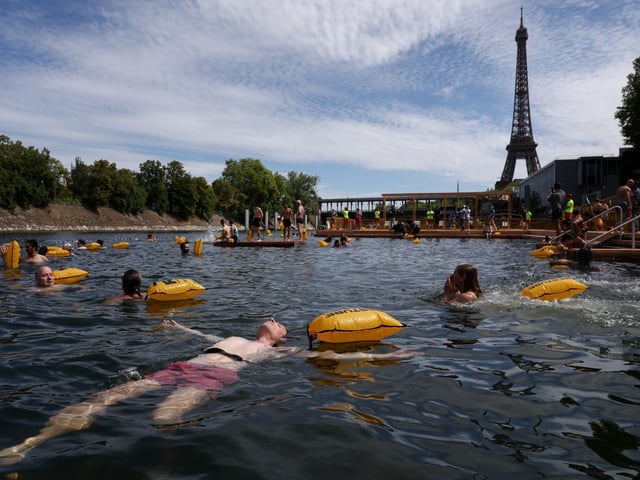 PARIS, FRANCE - JULY 5: Members of the public swim at the Baignade de Grenelle bathing site on its opening day on July 5, 2025 in Paris, France. Mayor of Paris Anne Hidalgo is visiting three bathing sites as the city launches its inaugural season of public swimming in the River Seine for the first time in just over a hundred years. Hidalgo had made it a promise of her time in office to make the Seine swimmable again ahead of the 2024 Summer Olympics in Paris, with the city investing 1.4 billion euros in a clean-up project. Swimming in the Seine had been banned since 1923, due to the dangers of boat traffic and poor water quality. The new bathing areas offer changing areas and will be monitored by life guards for the swimming season, from July 5 to August 31. (Photo by Tom Nicholson/Getty Images)