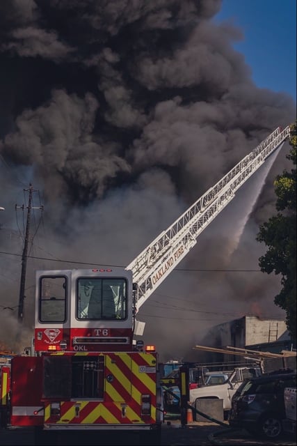 Oakland firefighters battle a warehouse blaze Friday, a day that saw an exhausting 64 fires around the city, up from the usual dozen.