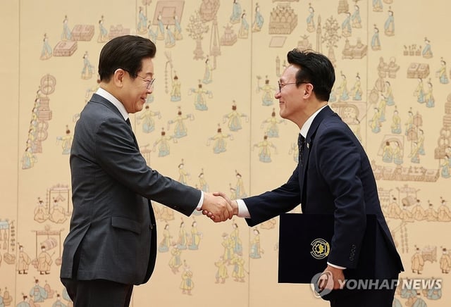 President Lee Jae Myung (L) shakes hands with Prime Minister Kim Min-seok after presenting him with a certificate of appointment during a ceremony held at the presidential office in Seoul on July 4, 2025. (Pool photo) (Yonhap)