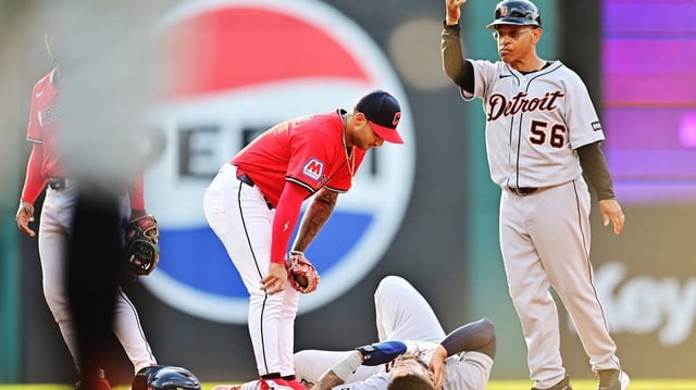 Jul 5, 2025; Cleveland, Ohio, USA; Detroit Tigers third base coach Joey Cora (56) motions to the dugout for medical personnel to come and look at second baseman Gleyber Torres (25) after Torres was injured during the first inning against the Cleveland Guardians at Progressive Field. Mandatory Credit: Ken Blaze-Imagn Images