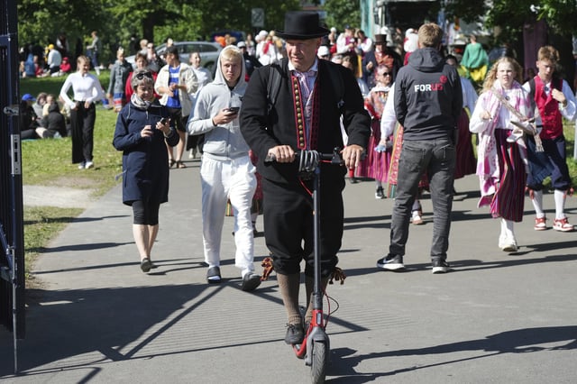 A participant rides a scooter ahead of the Estonian Song and Dance Celebration "Iseoma" at the Kalev Stadium in Tallinn, Estonia, Friday, July 4, 2025. (AP Photo/Sergei Grits)