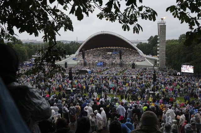 Choir singers take part in the Estonian Song Festival, part of the "Iseoma" Song and Dance Celebration, at the Song Festival Grounds in Tallinn, Estonia, Saturday, July 5, 2025. (AP Photo/Sergei Grits)